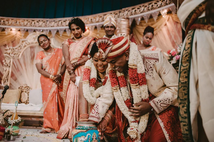 bride and groom play fishing the ring during london hindu wedding