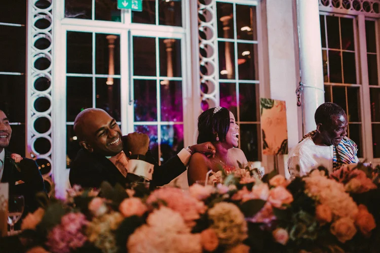 bride and groom laughing at best mans speech during wedding reception at syon park