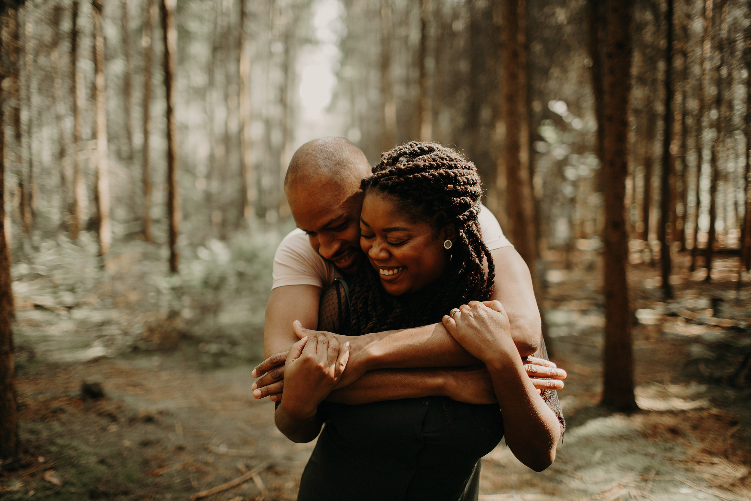 engaged couple share a laugh with each other in the black park