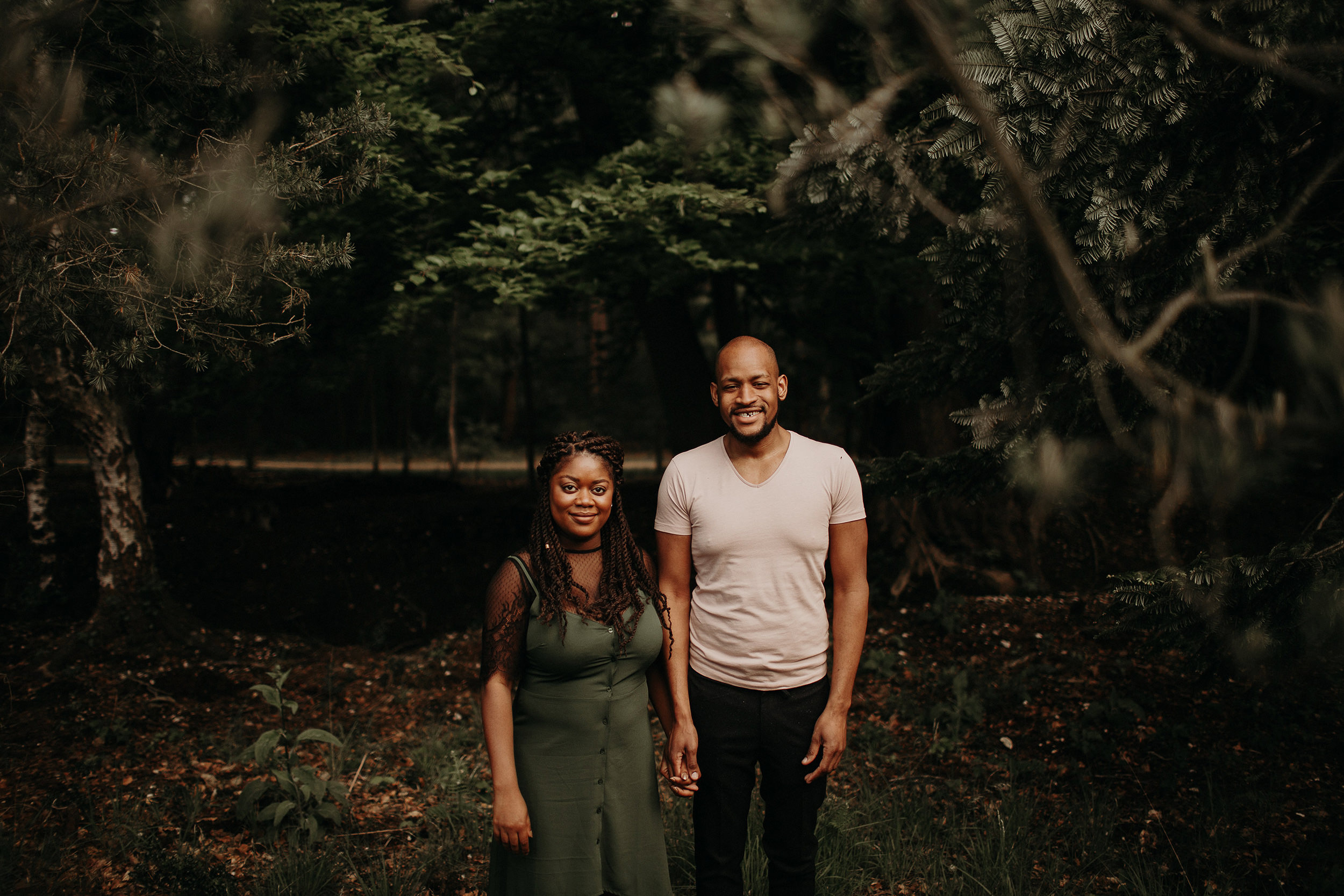 engaged couple hold hands in black park