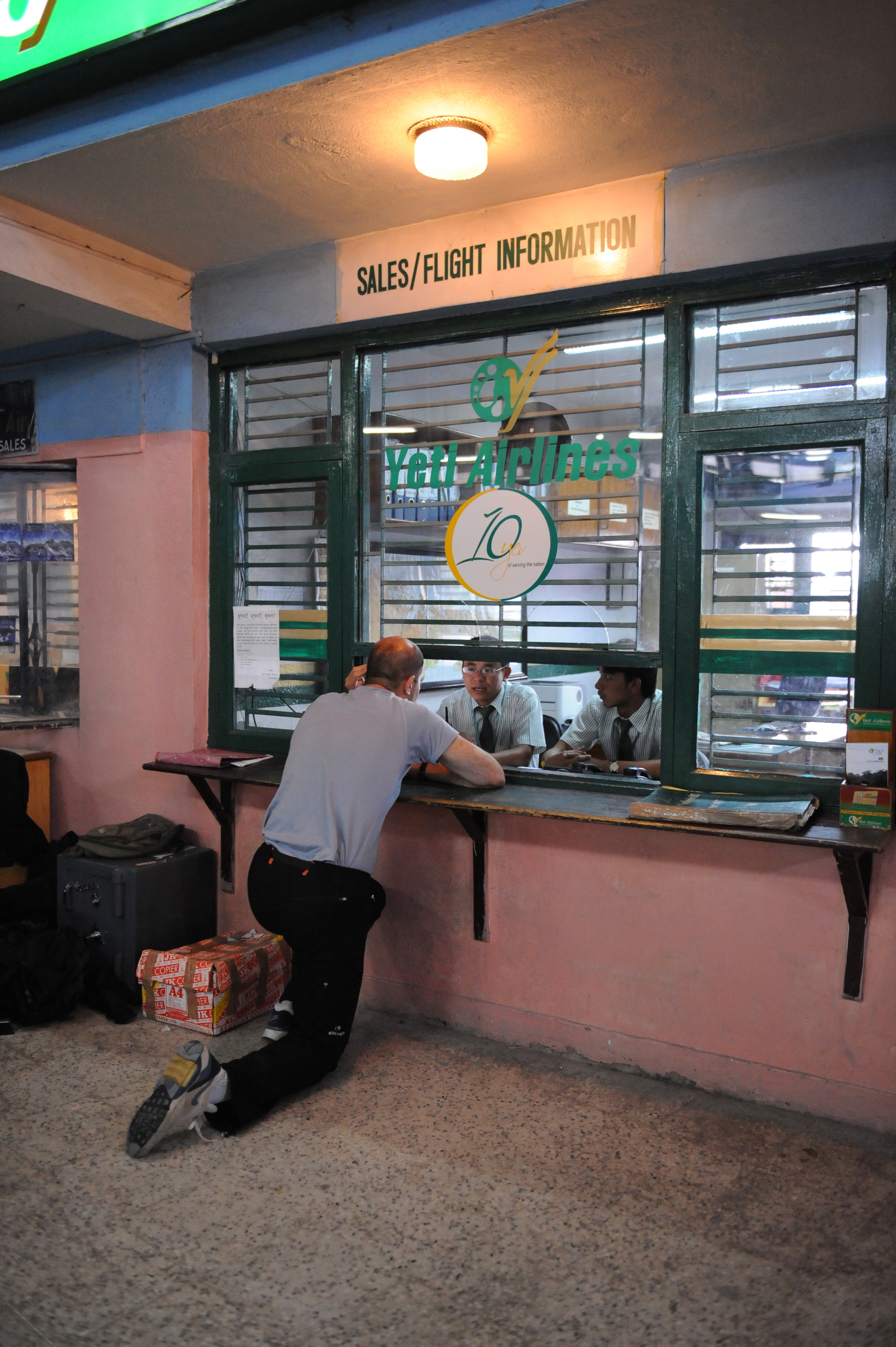 Yves 'prays' for early departure at Yeti Airlines' office.