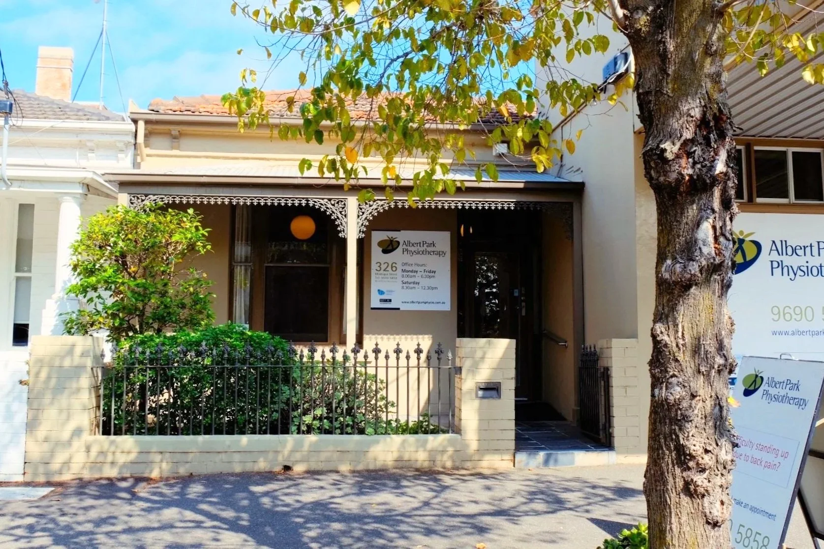 Exterior of Albert Park Physiotherapy clinic with a sign displaying office hours and contact information.