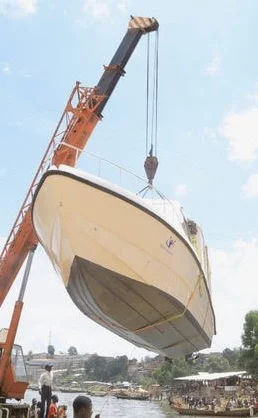The boat being lifted off the truck and lowered into lake idjwi.