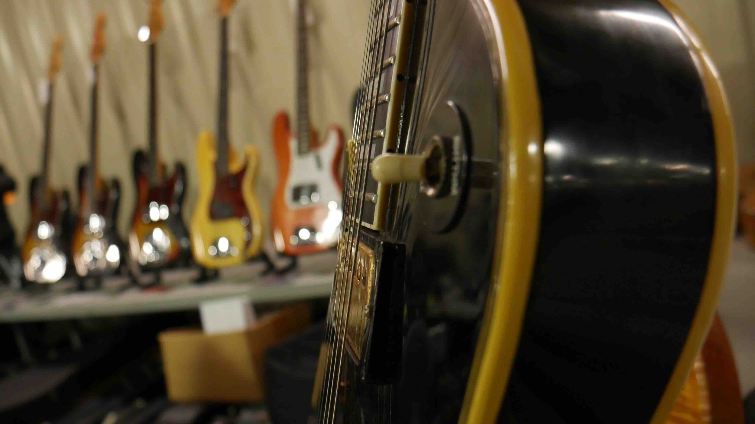 les paul with fender basses in background.jpg