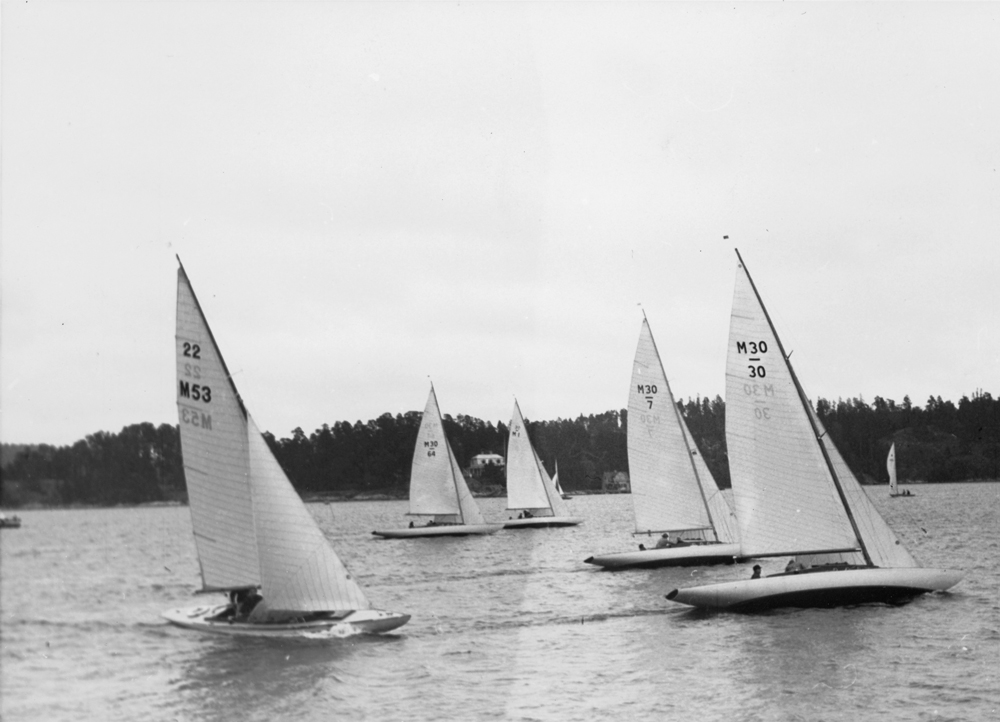 ....Mälar 22 BEATRICE (M53) sailing in a KSSS race autumn 1944 behind Mälar 30 boats. Photo: Digitaltmuseum.. Mälar 22 BEATRICE purjehtii KSSS:n kisassa isoveljiensä, Mälar 30 -veneiden, perässä syyskuussa 1944. Kuva: Digitaltmuseum....