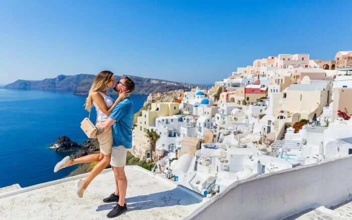 Young-couple-looks-down-on-the-landscape-of-the-island-of-Santorini-ss08082017.jpg