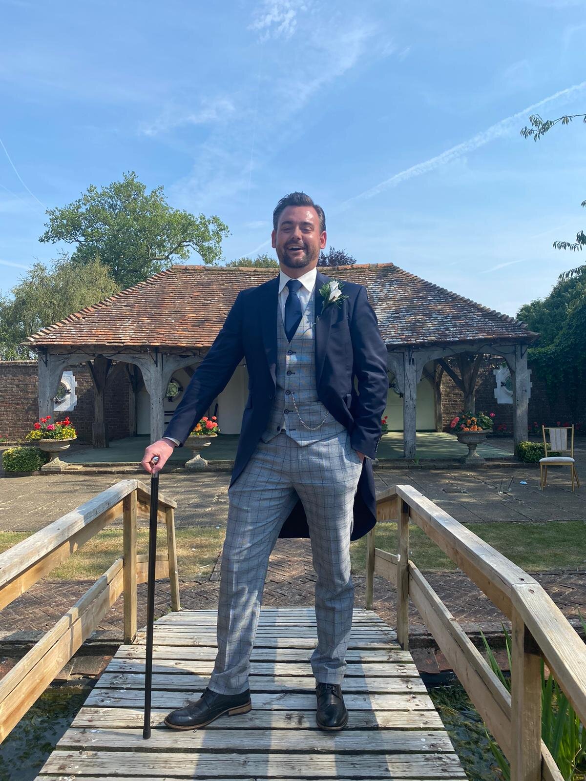 kent groom suit with cane on bridge