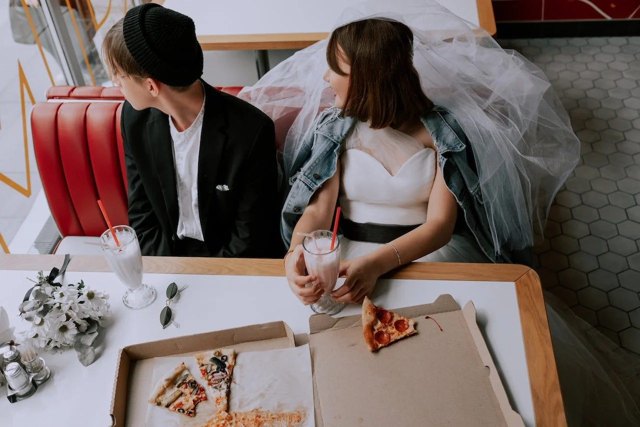young bride and groom eating pizza luxury wedding details