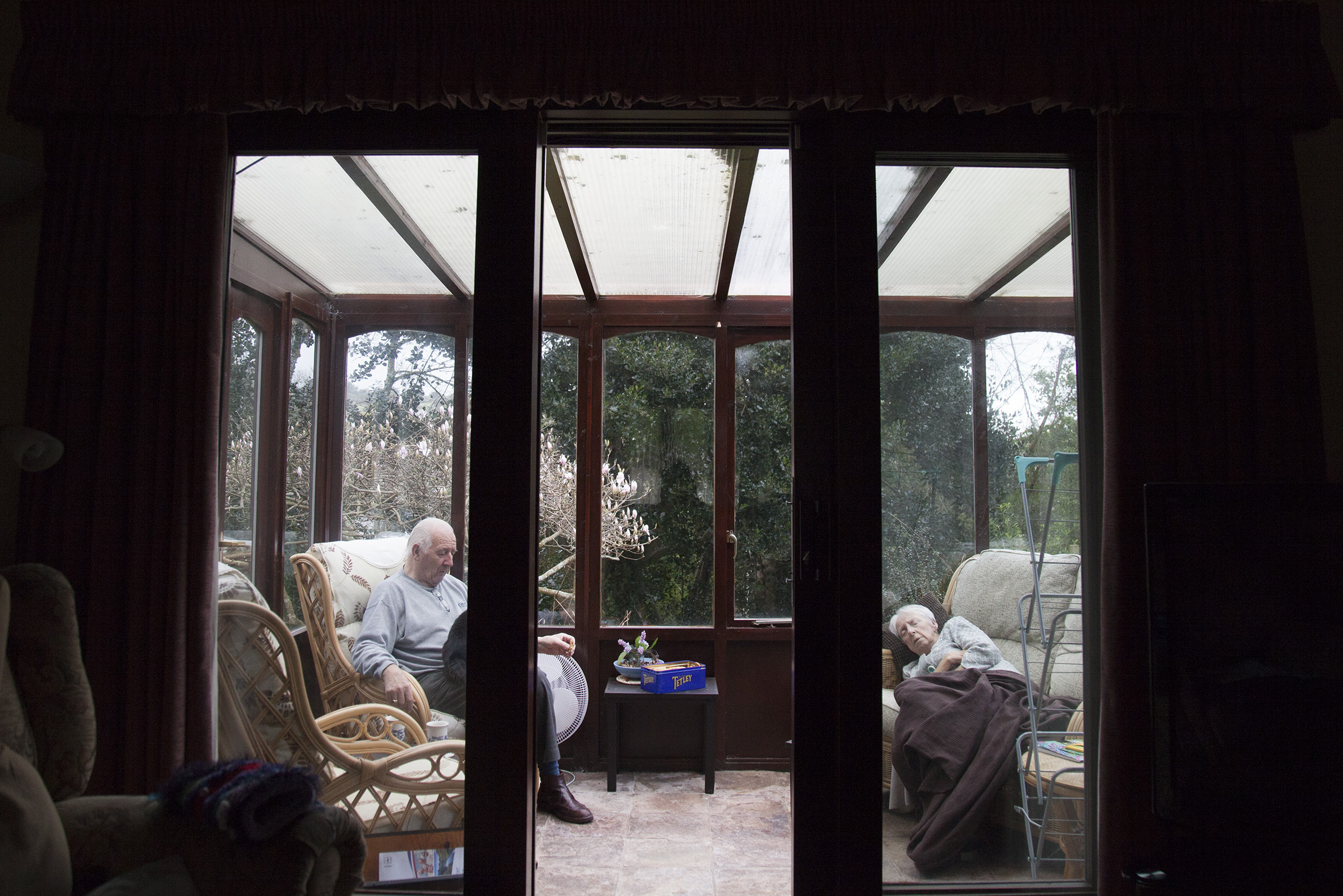 Graham and Lilyan sitting down in their living room drinking their tea. 