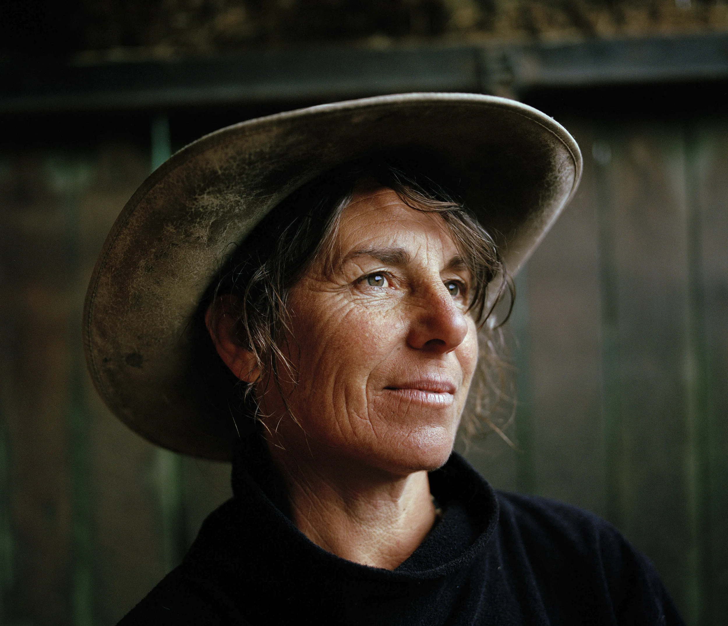 A portrait of Catherine Hoskin standing in her stables, after being out for a morning horse ride. Although Catherine feels that the western way of riding has more freedom, her passion lies with the relationship she has with the horses rather than the western culture.