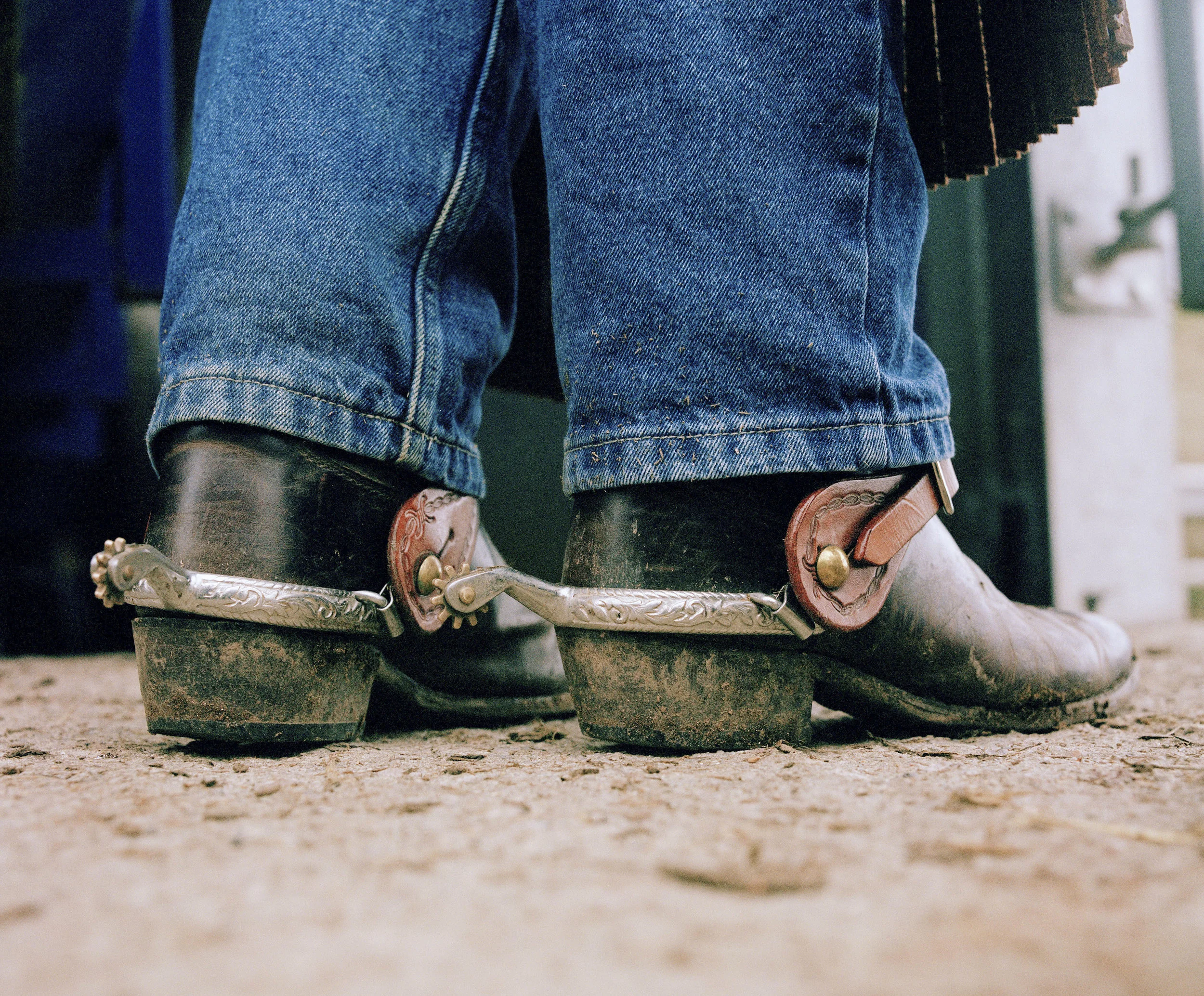 Nick Michelle’s riding boots, standing on the ground of Hemborough farm. The rodeo riders wear original gear to compete and ride in.