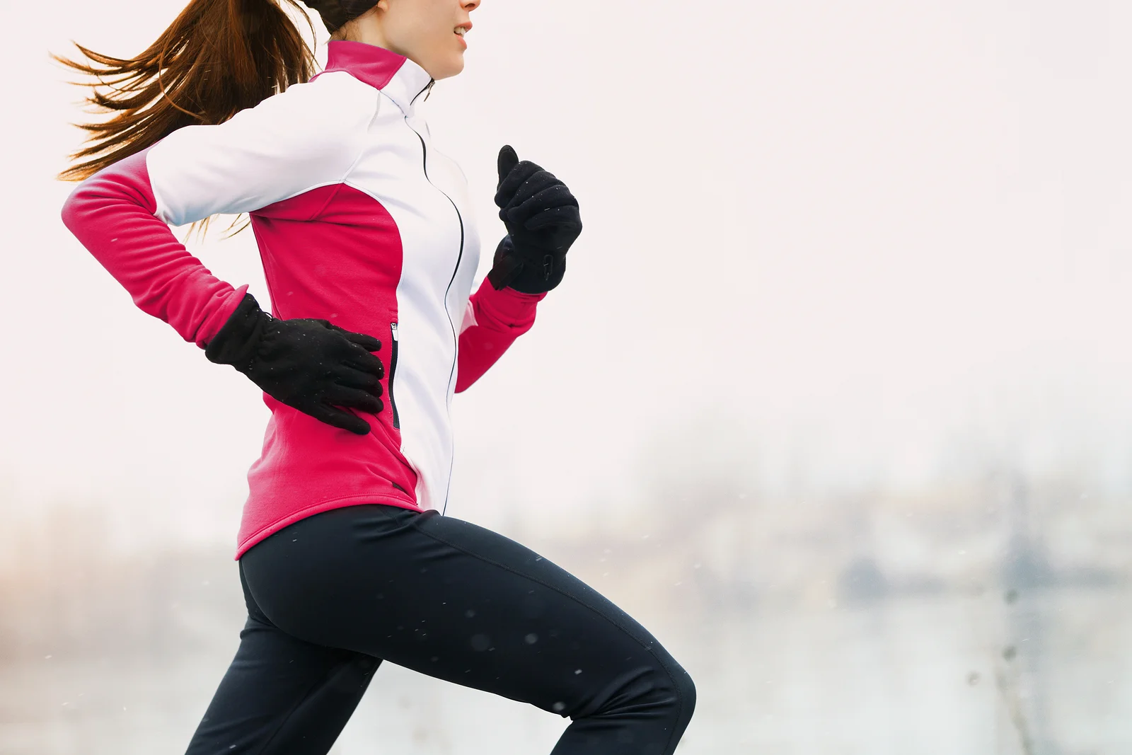 Winter running athlete woman on cold run jogging fast with speed