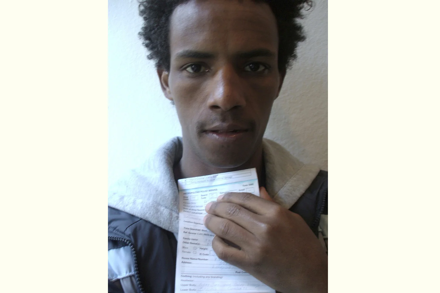 This picture is interesting and makes me wonder. It was the first time I came into contact with the police in England. I was stopped and searched when I was waiting for Crispin outside Downing Street. Afterwards I took this self-portrait holding the piece of paper they gave me. Mussie Haile, excerpt from They Seem To Be Ours But They Are Not … , New Londoners (PhotoVoice / Trolley 2008)