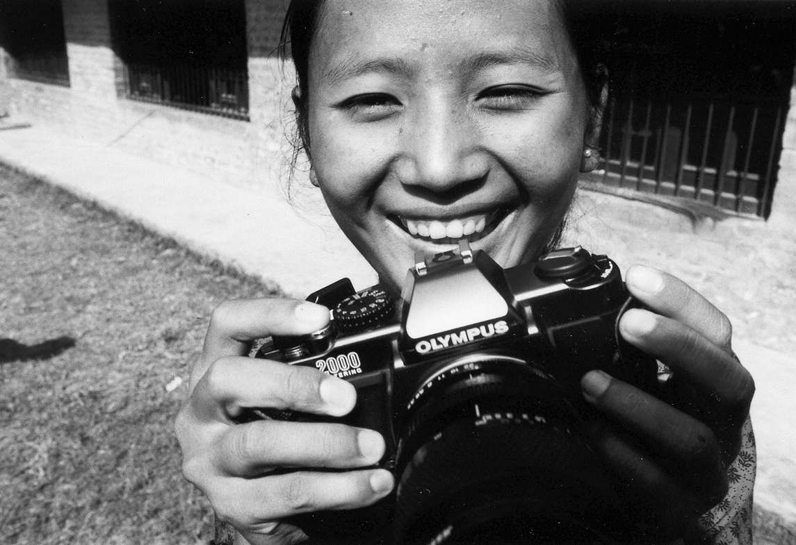 Playing with camera outside the exhibition, PhotoVoice participant, Kathmandu, Nepal 2003 (c) Tiffany Fairey
