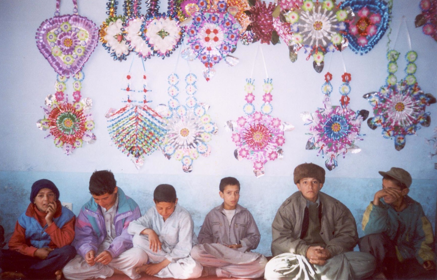 Making decorations at Aschiana These children are making flowers to sell on the street. These kinds of decorations are traditional in Afghanistan, people will use them to decorate their houses and also brides will use them. During Eid we also decorate our house. This year Eid was very different to last year because the Taliban are gone. Last year I did not understand what a holiday meant because everyday I had to be in the house but this year we were dismissed from school and Aschiana – now I understand what a holiday means. Before I was not at school so everyday was like a holiday because we could not work or study, we had to stay inside. It felt good to have a holiday. I used to get bored always staying at home. There was nothing to do each day except when we could work on the streets. (c) Rabia / Shooting Kabul / PhotoVoice