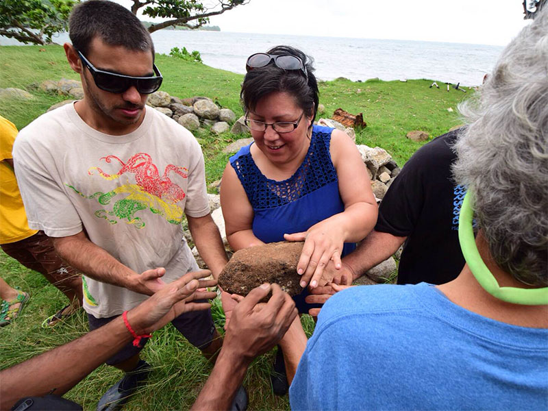 Denna Duncan, SEAS Coordinator, Kitasoo/Xai'Xais Nation in British Columbia, moves boulders and stones with an international crew helping to restore huilua , a fish pond or traditional aquaculture system. 