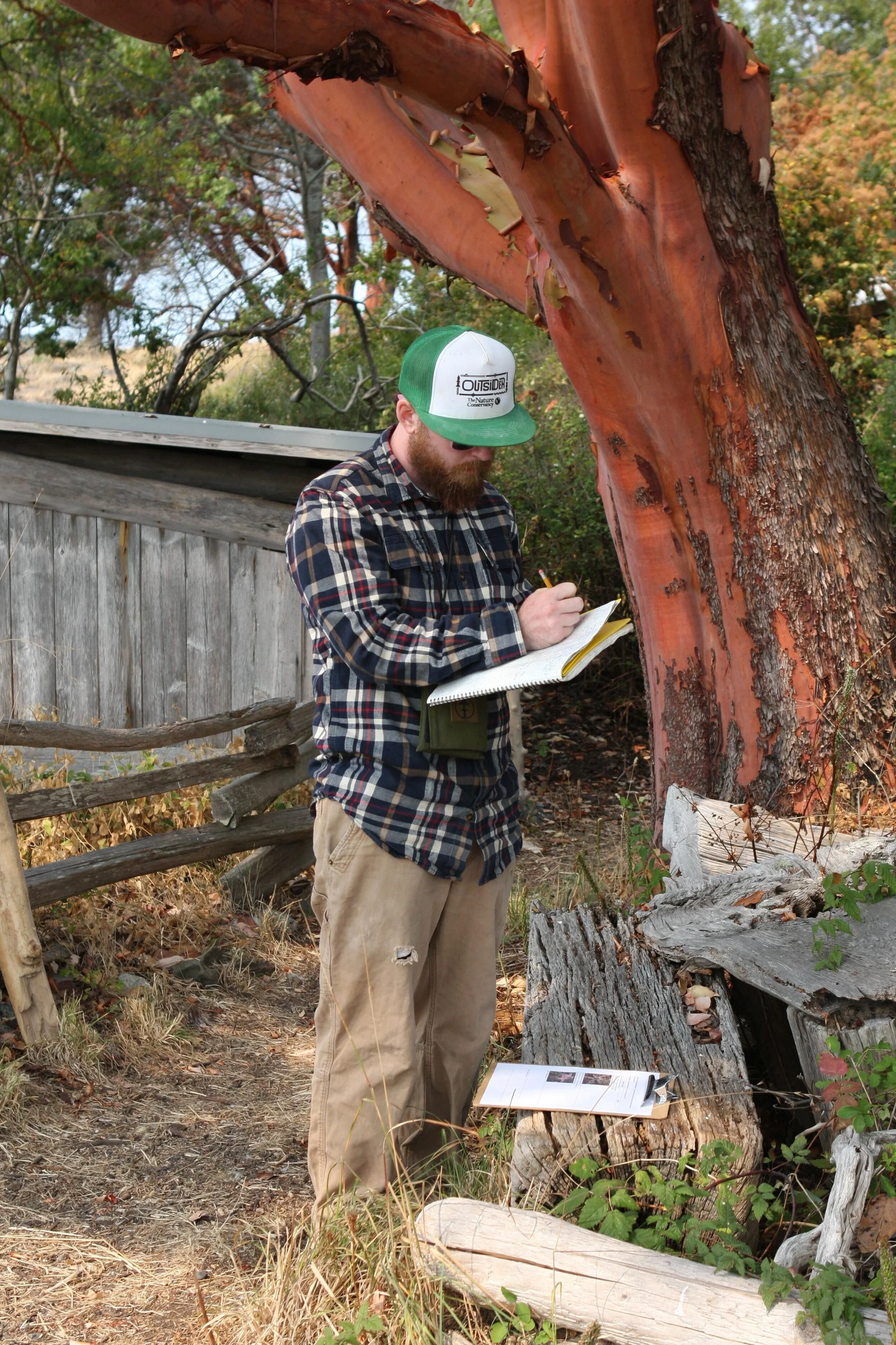 Trenton Turner signs in at the Yellow Island Preserve’s Visitor Log. Photo by Heather Van Steenburgh.