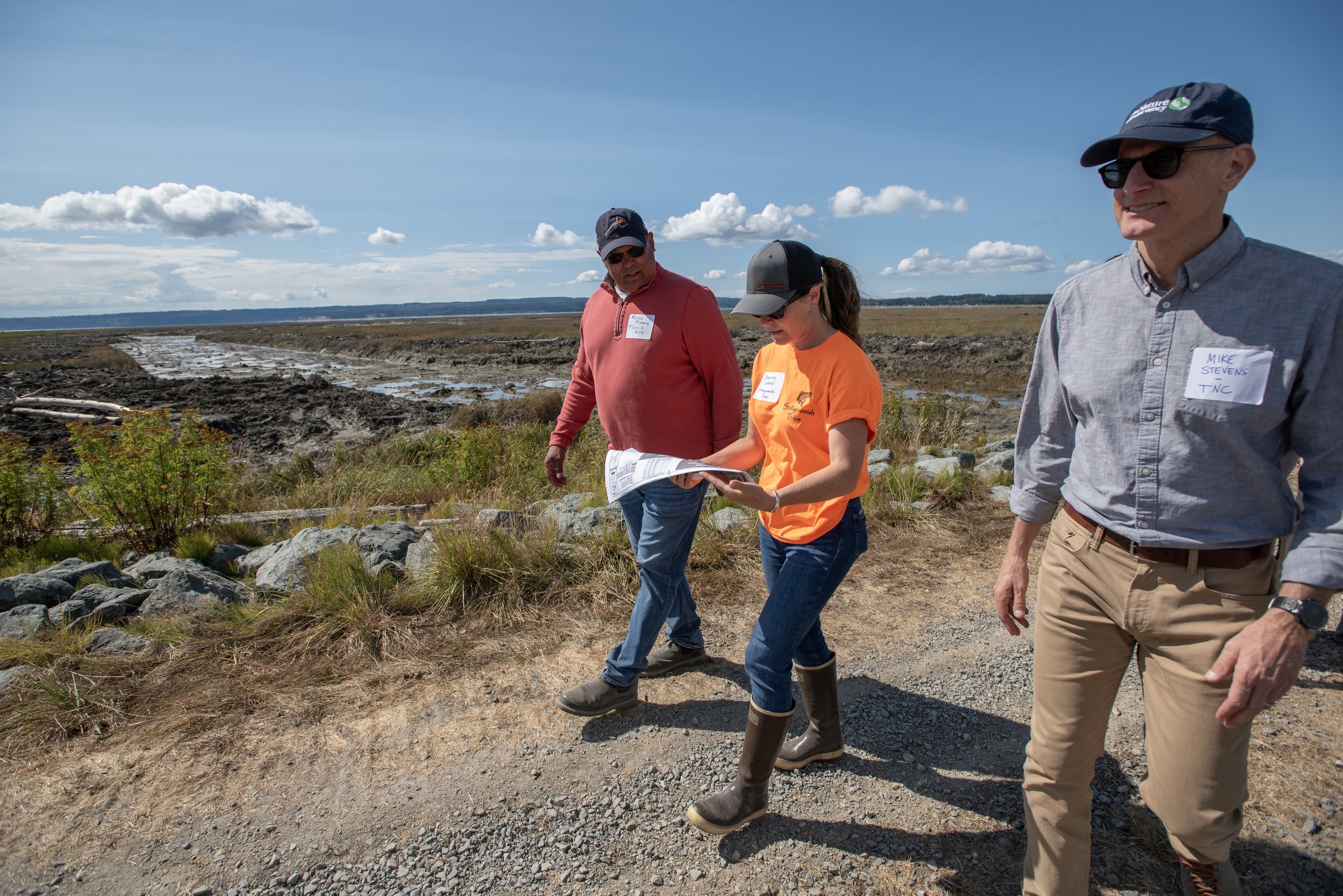  Tulalip Tribal Councilmember Marlin Fryberg Jr, Charlotte Scofield Fisheries Biologist for the Stillaguamish Tribe, and TNC Washington state director Mike Stevens walk along the estuary talking about the restoration plans. © Hannah Letinich/TNC 