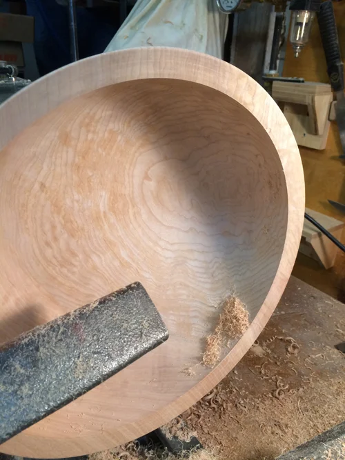 When dry, the roughed out blank is remounted on the lathe, brought back into round to even out any warping that happened during the drying process, and then finish turned and sanded on the lathe.