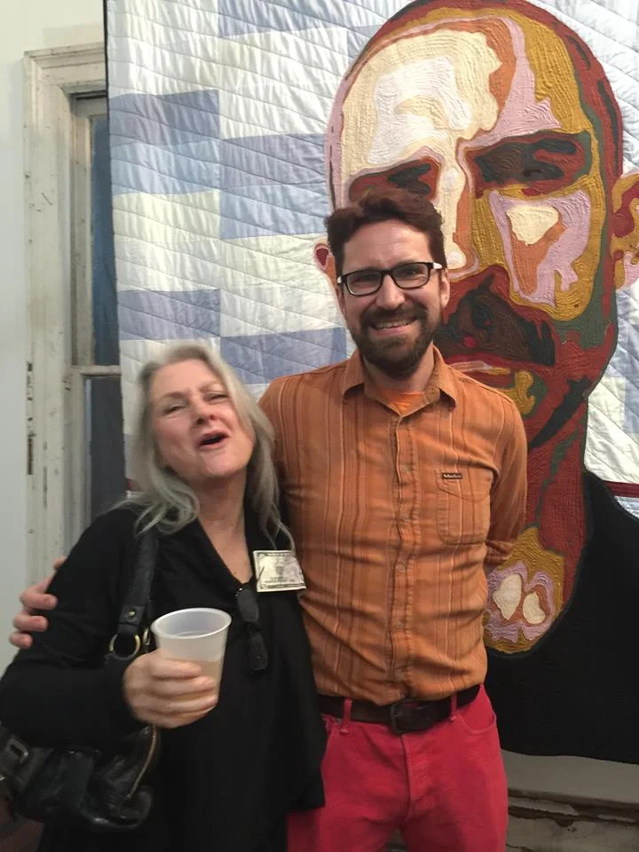 Peter and a friend at the opening, with one of the quilt portraits in the background