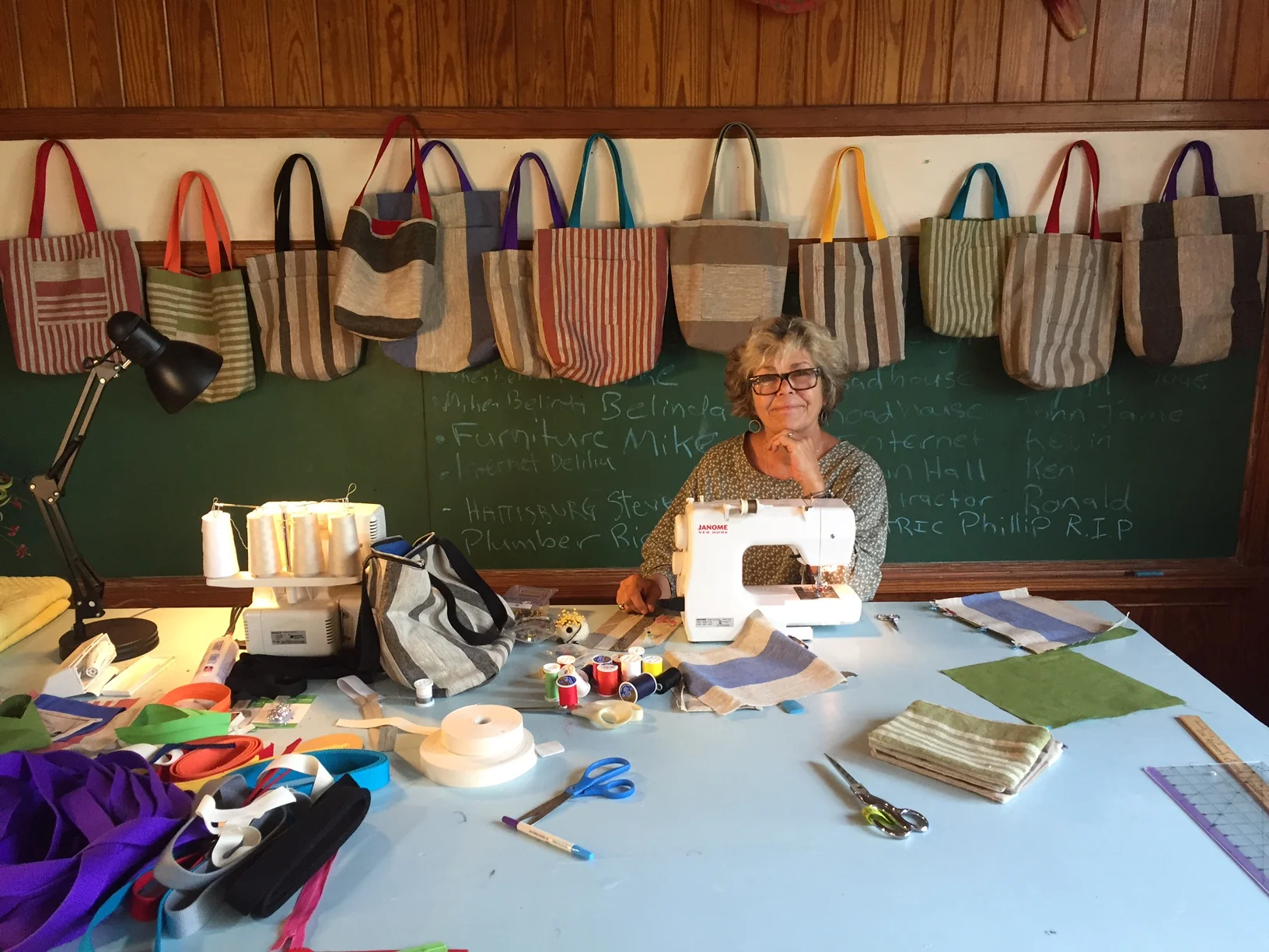 Kate in the studio, back and forth between her sewing machine and serger to make her linen tote bags. 