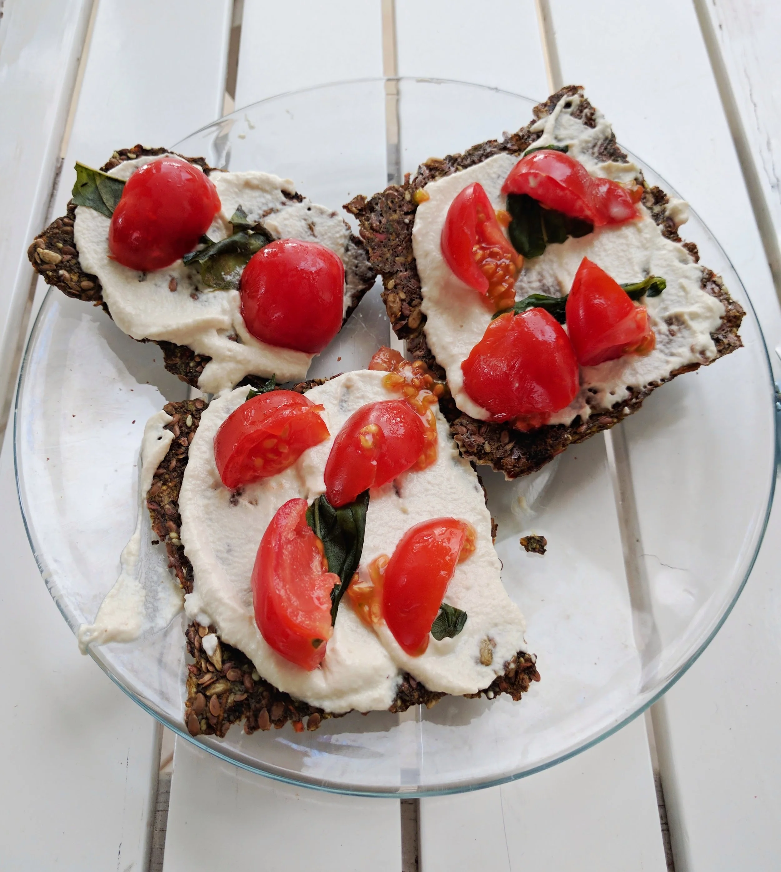 Raw, vegan pizza bites: raw, vegan flax seed crackers topped with cashew cheese, basil and cherry tomatoes. Costa Rica
