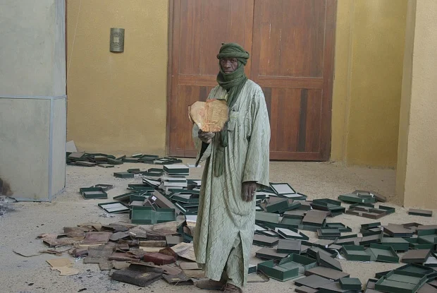 A man holds a burnt manuscript in Timbuktu, 31 January 2013. Photo: © UNESCO Bureau of Mali