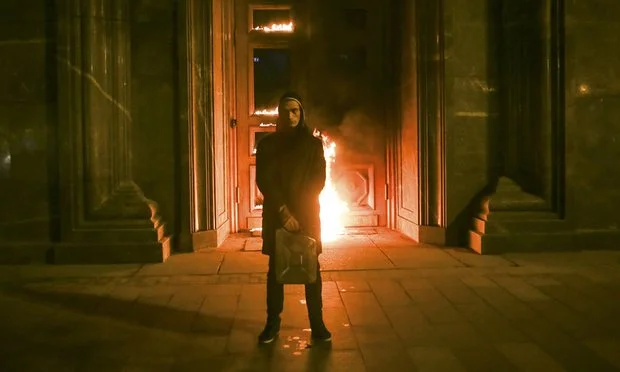 Pavlensky in front of the burning FSB doors. Photo Credit: Reuters.