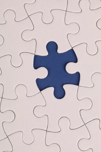 White puzzle with one piece missing over a blue background