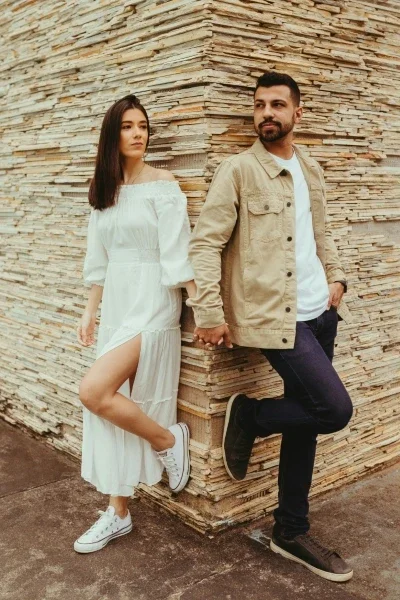 Couple standing together at the corner of a wall