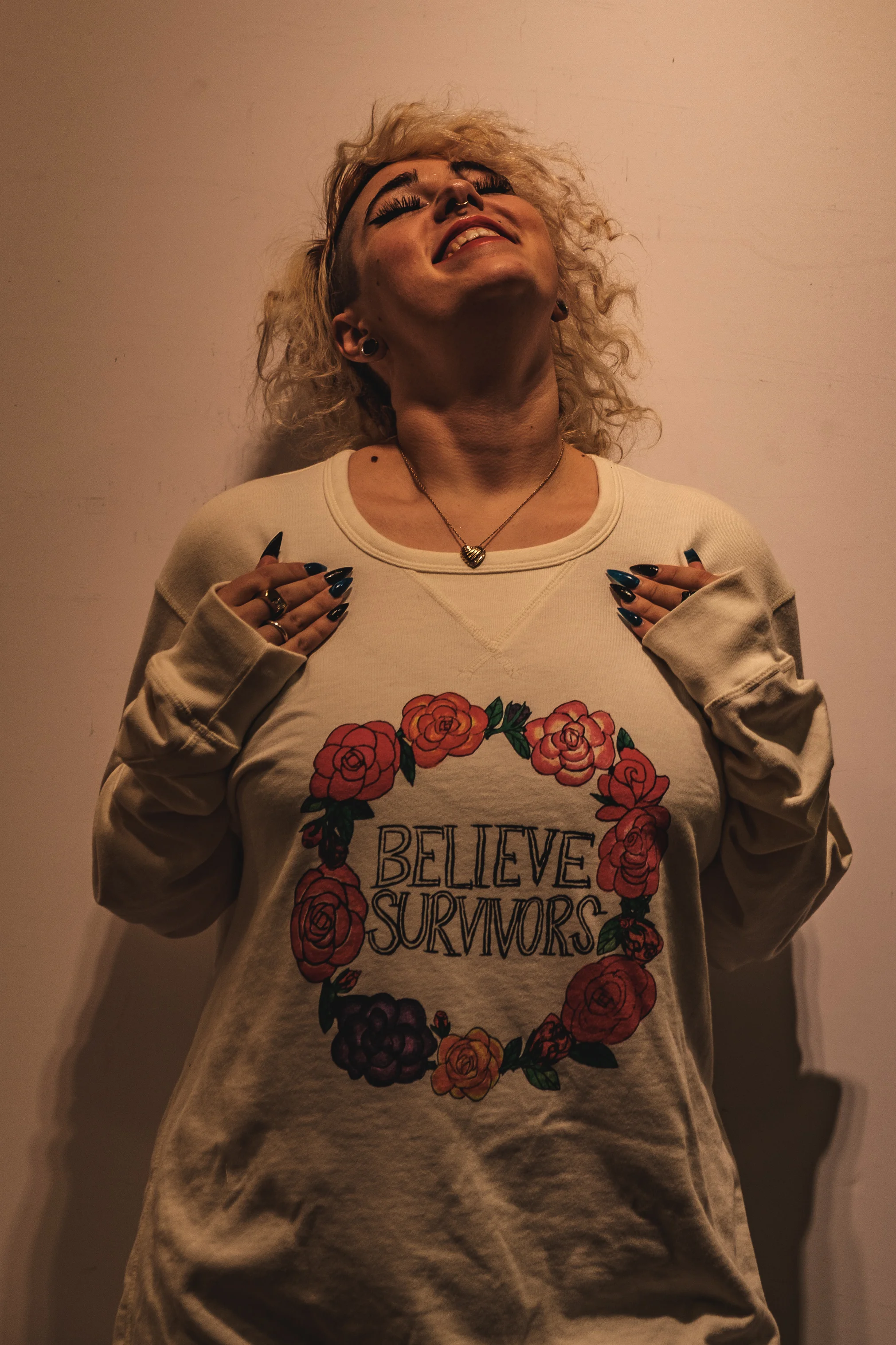 white unisex sweatshirt with "believe survivors" text inside ring of flowers graphic - dfrntpigeon