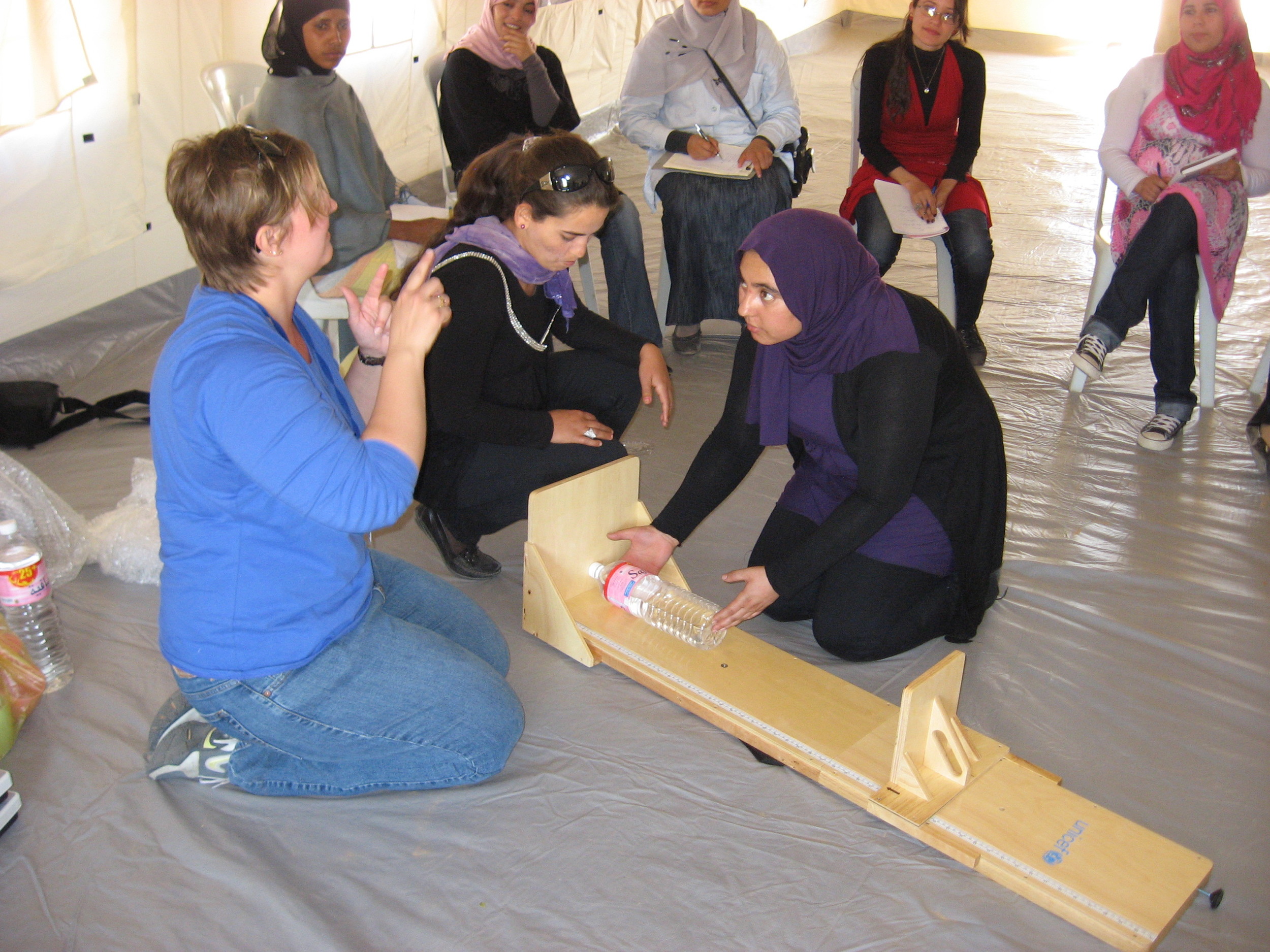 Training staff on how to take a child's height using a water bottle at a refugee camp on the Tunisian border.