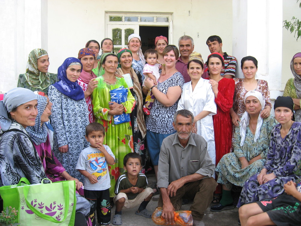 Sonya holding a baby surrounded by a group of Tajik women that participated in a focus group discussion on child health.