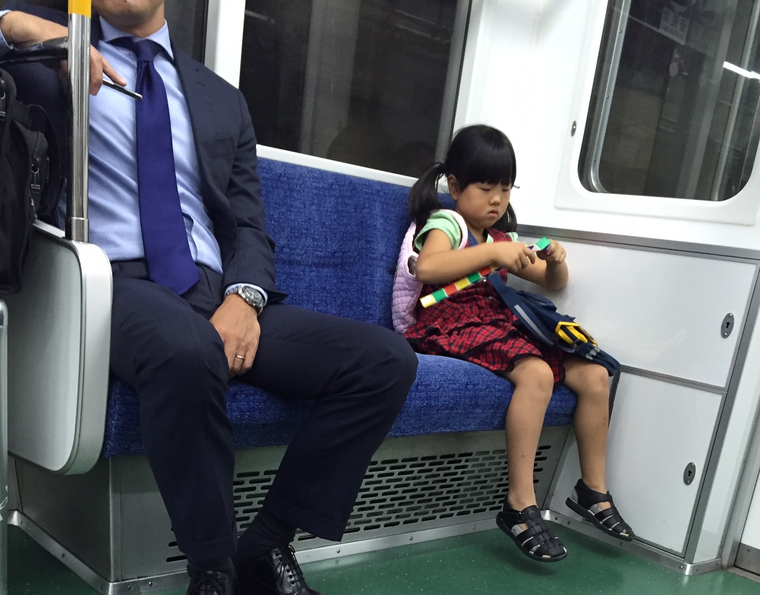 small child on subway plays with complicated toy