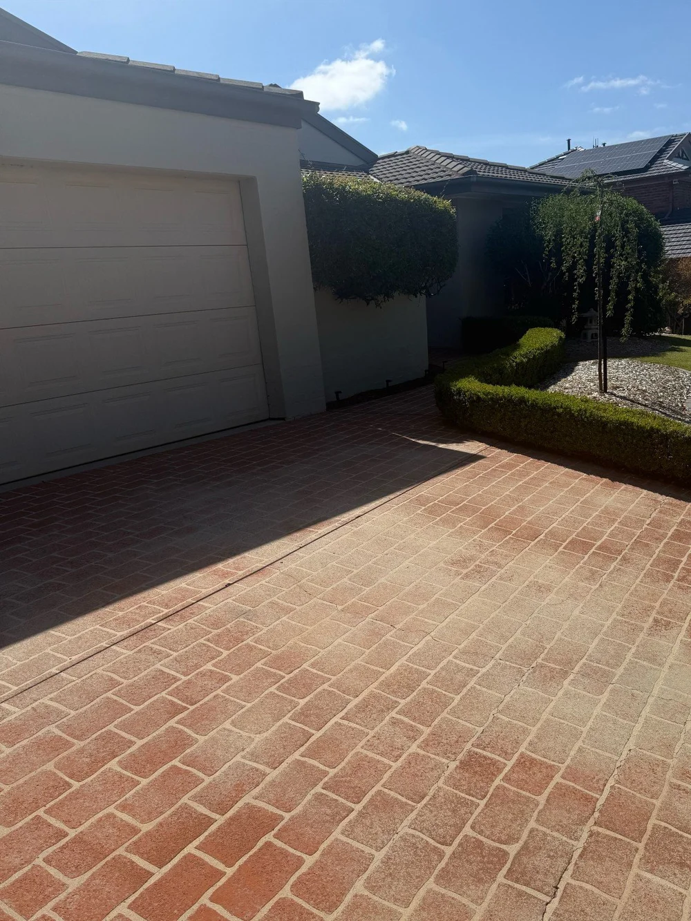 Red driveway before cleaning and resealing in Canberra