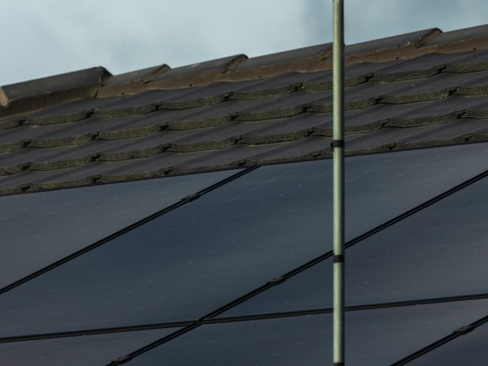 Solar panels and a TV antenna on a tiled roof