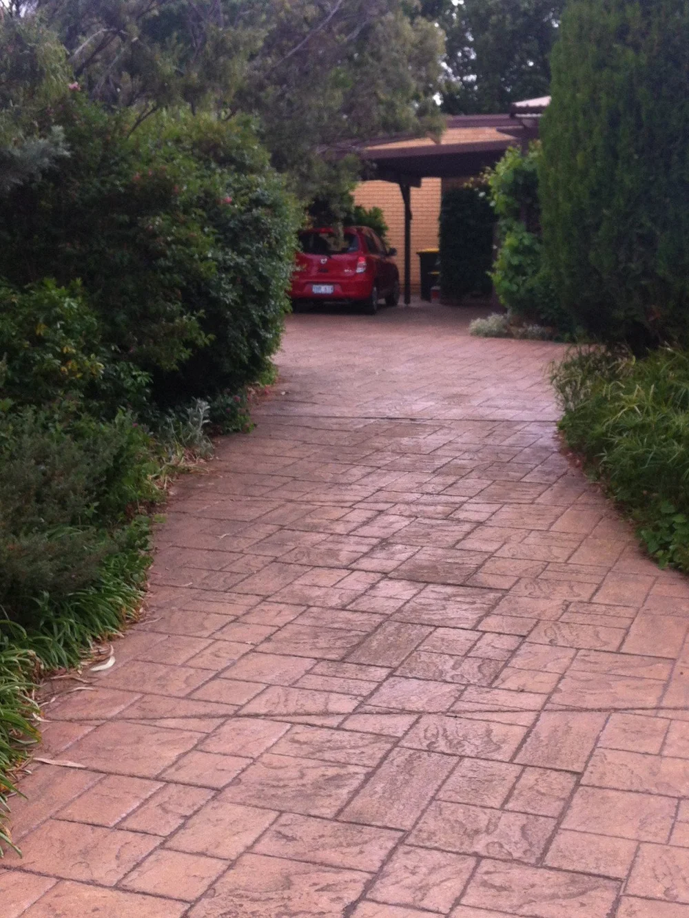 Dull stamped concrete driveway before cleaning and sealing in Canberra