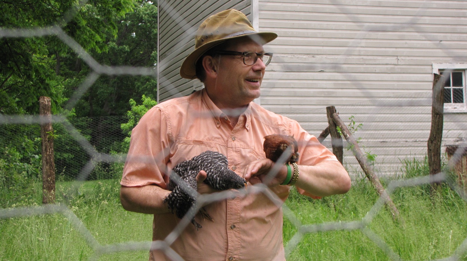 Dunes Learning Center executive director Geof Benson hangs out with the new residents in the chicken coop’s fenced yard.