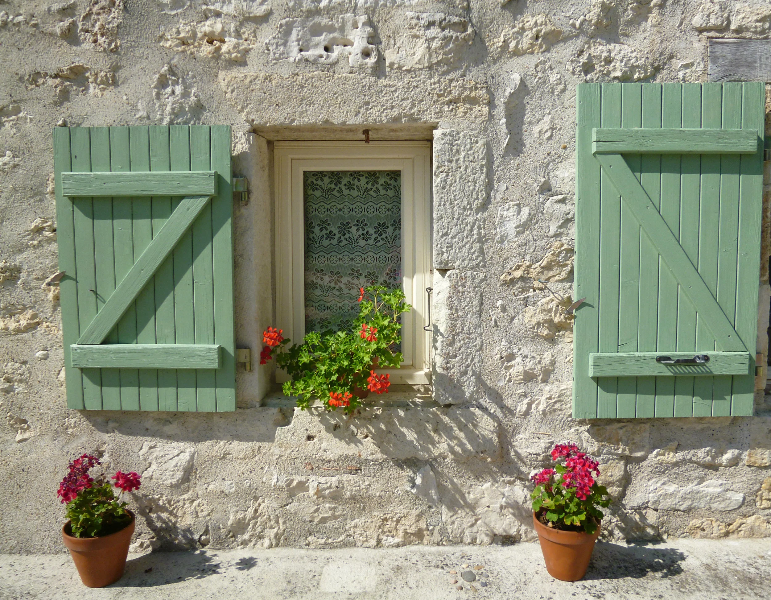 The green shutters supported (photographically) by the geraniums.