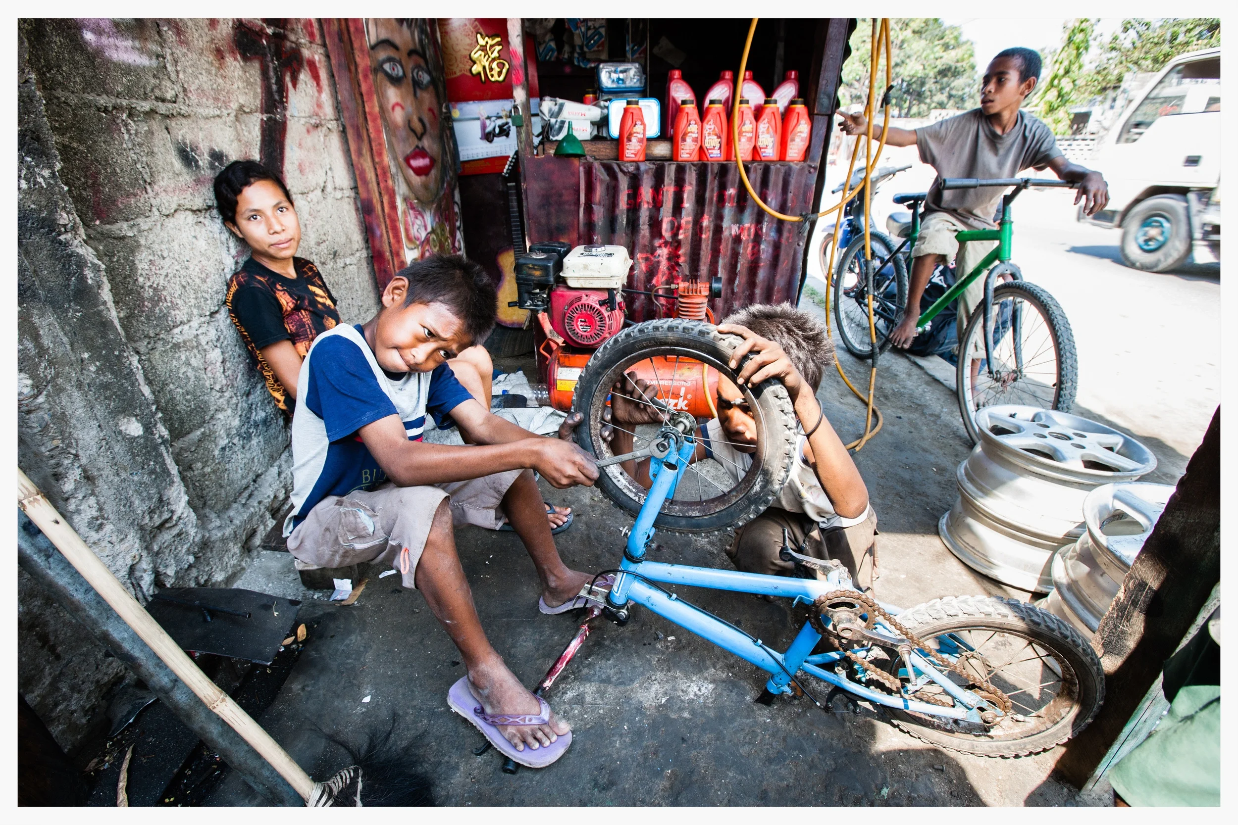 A group of boys run a tyre repair shop, missing out on school. East Timor. Photo: © Marcus Perkins