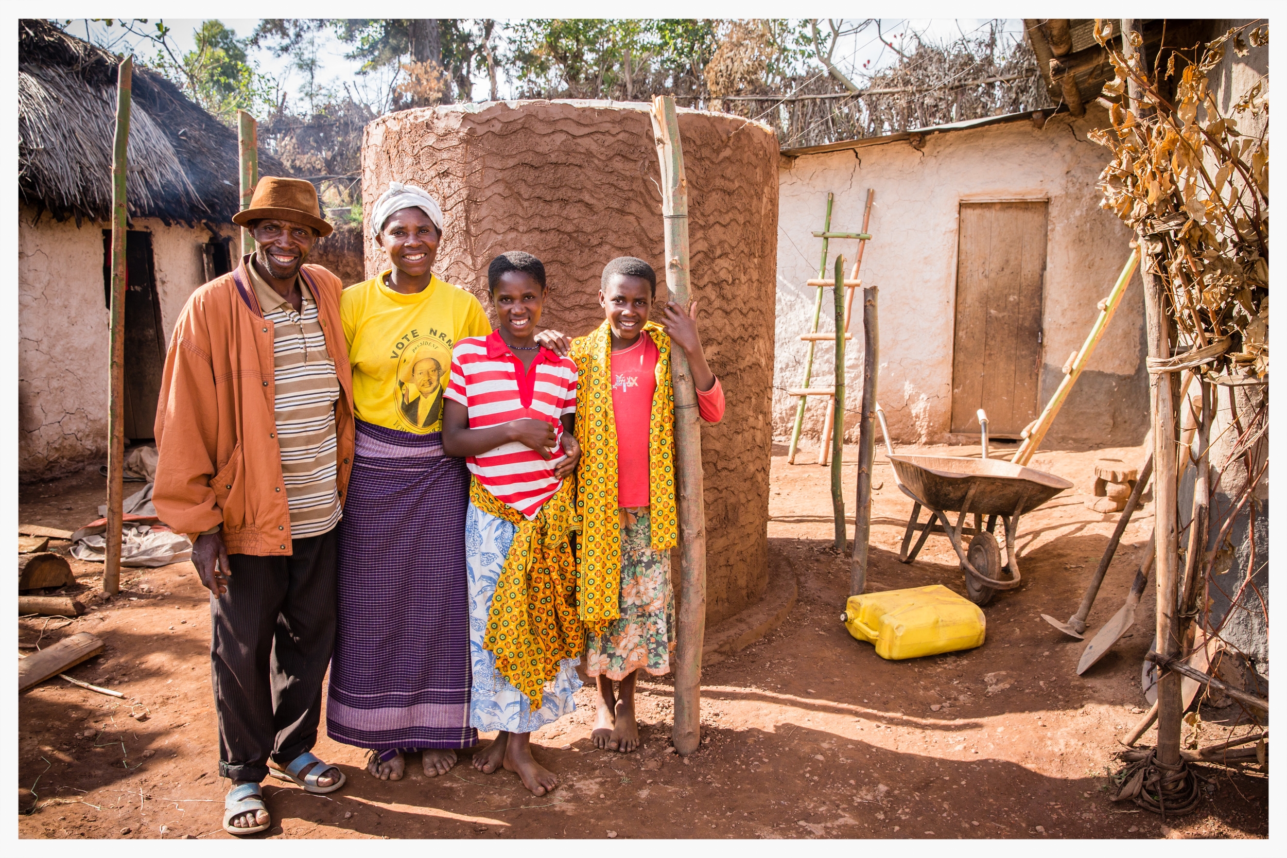 Milton and his family stand next to their water tank which will harvest rainwater from the roof of their home. Rwanyana village, south west Uganda. Photo © Marcus Perkins
