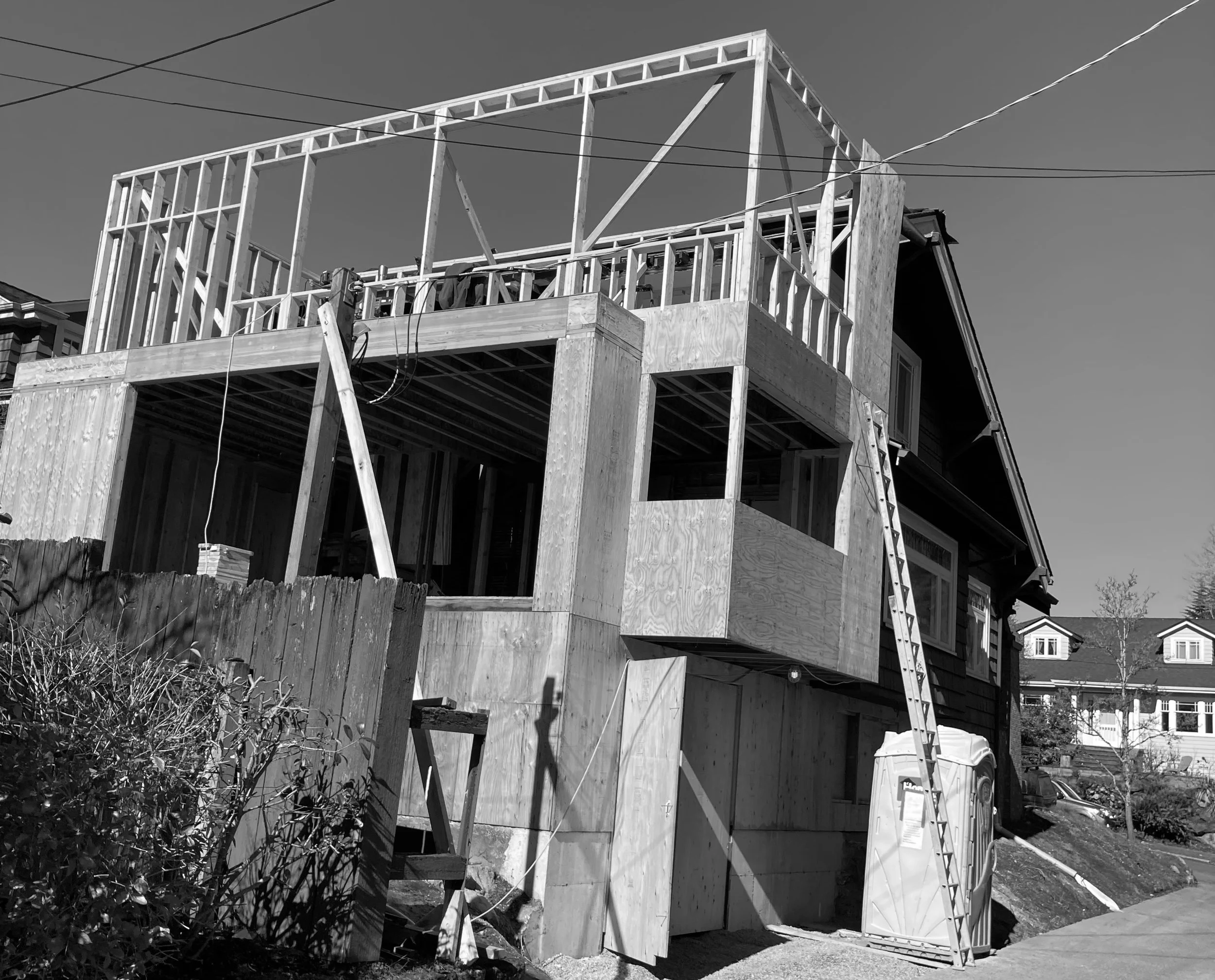 Construction site of a house with wooden framework and scaffolding in progress.