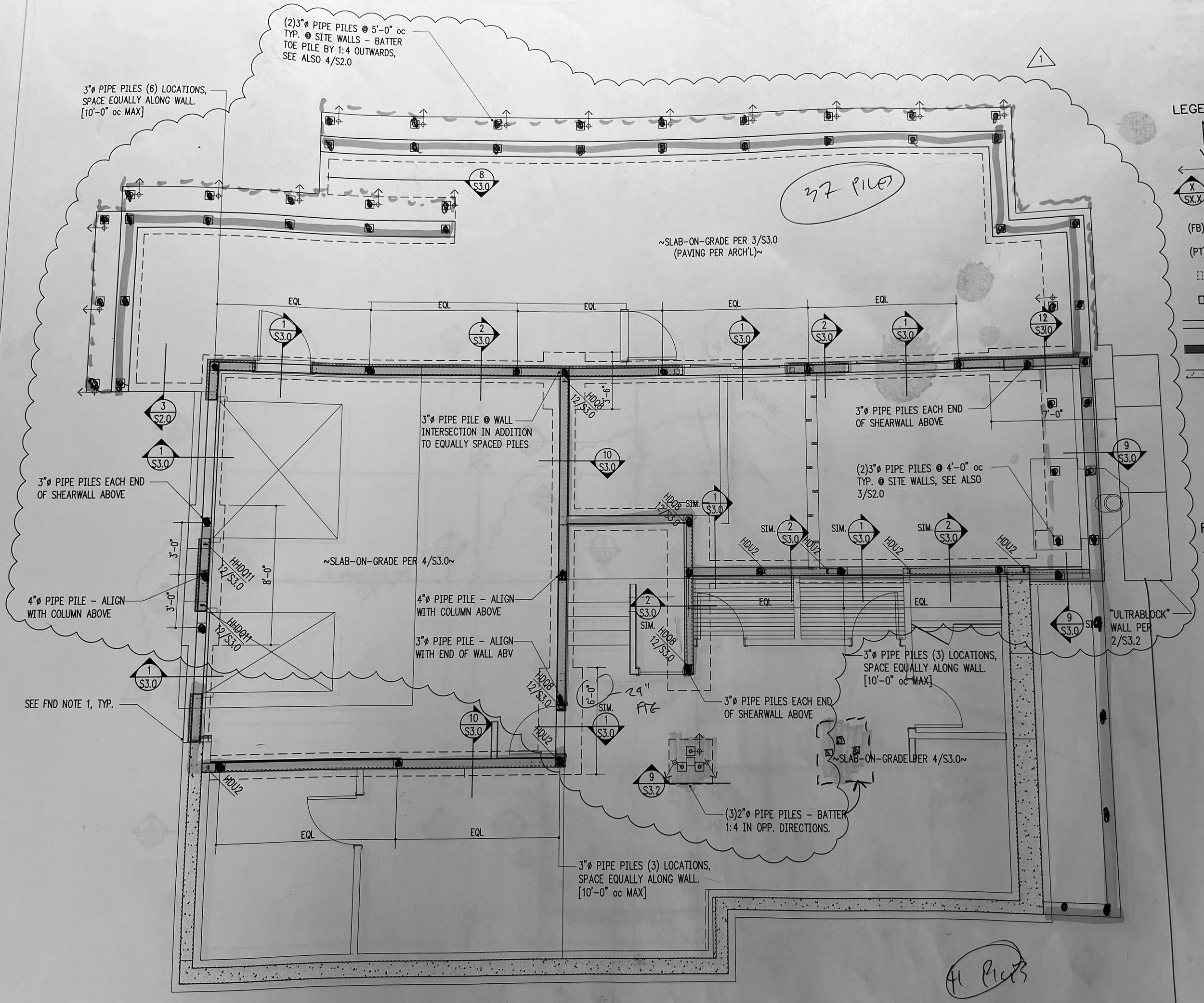 Architectural drawing of a building foundation with details on pipe piles, wall intersections, and spacing.