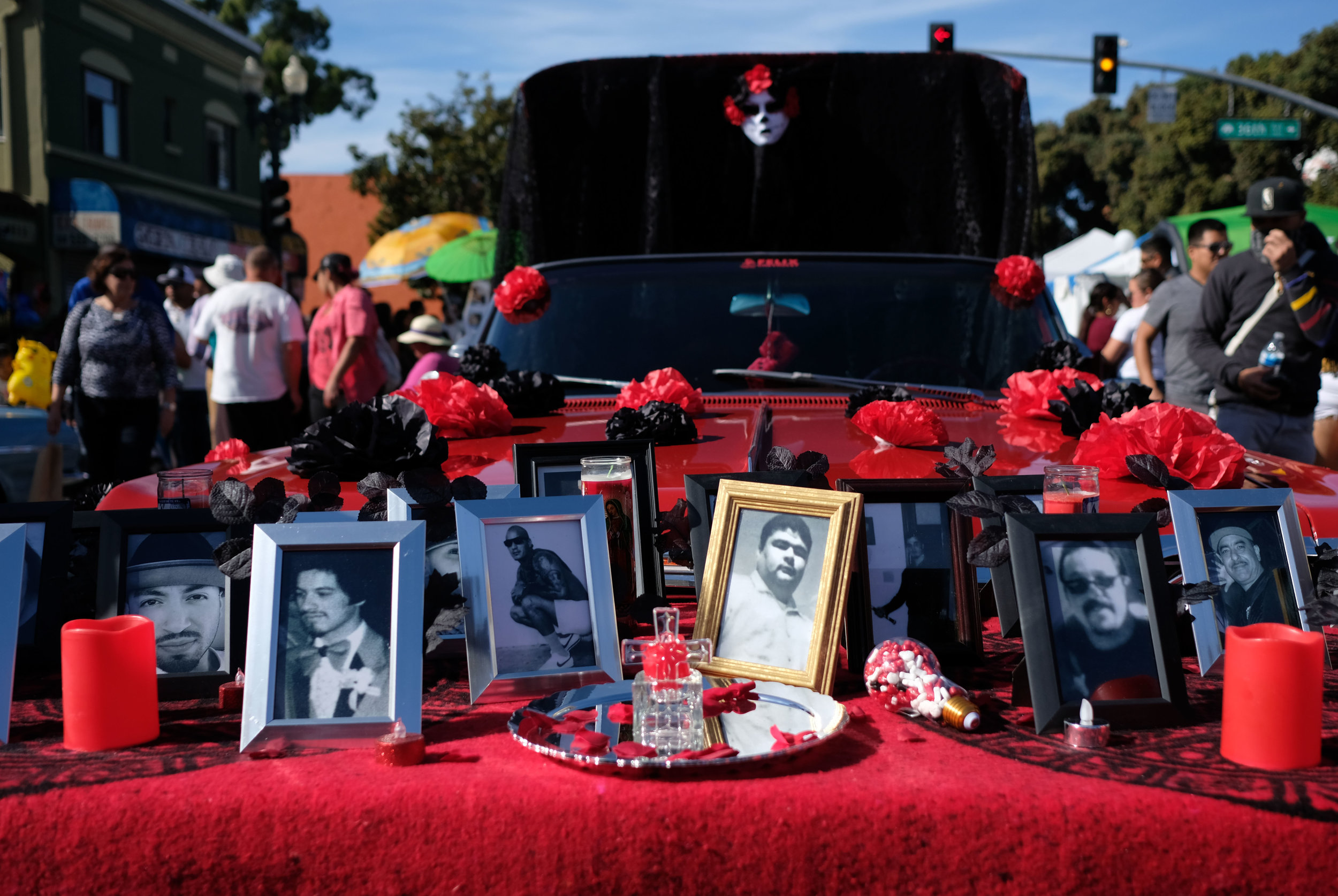  Framed portraits, as part of of a festival altar that includes a decorated lowrider, dedicated to local young men lost to violence.  International Boulevard, Oakland, CA.  