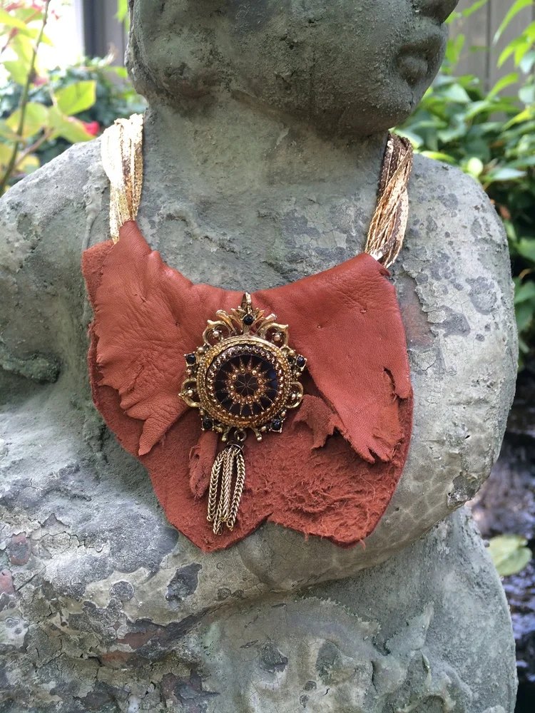 Give the gift of sophistication with our "Ruth" Necklace . It features a vintage gold chain necklace, adorned with leather, vintage brooch, and vintage tassel. 