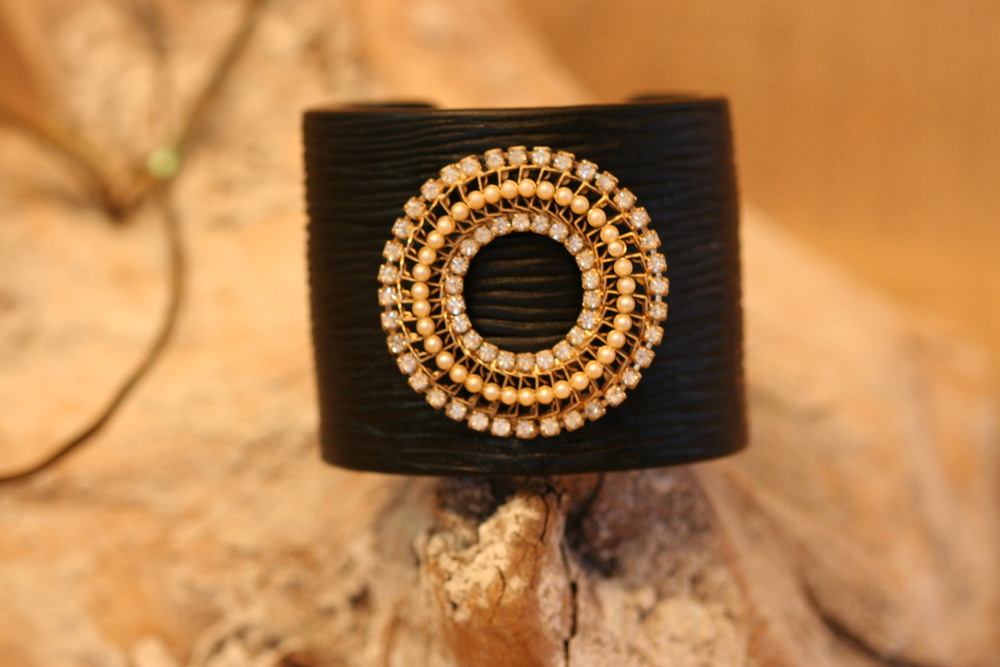  This is another stunning one-of-a-kind cuff from SCD. This black resin cuff is gorgeous, adorned with a vintage rhinestone and pearl brooch.&nbsp; 