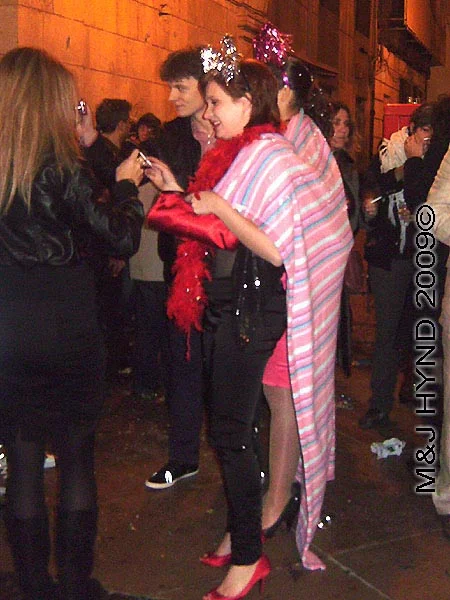 spain downtown Alicante, fiesta nochevieja New Years Eve, revellers party dress, pink shawl, feather-boa