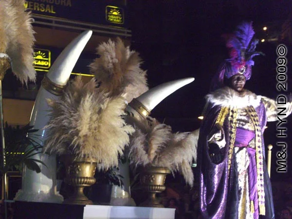 purple man – horns / parade #4: Spain Alicante Los Reyes Magos Three Kings' Fiesta Spanish Epiphany Christmas season, marching band, holiday parade religious floats carry King Caspar