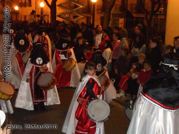 spain elche, Brotherhood black hood, long capes, procession, young marching drummer bands, near Townhall, crowded street parade