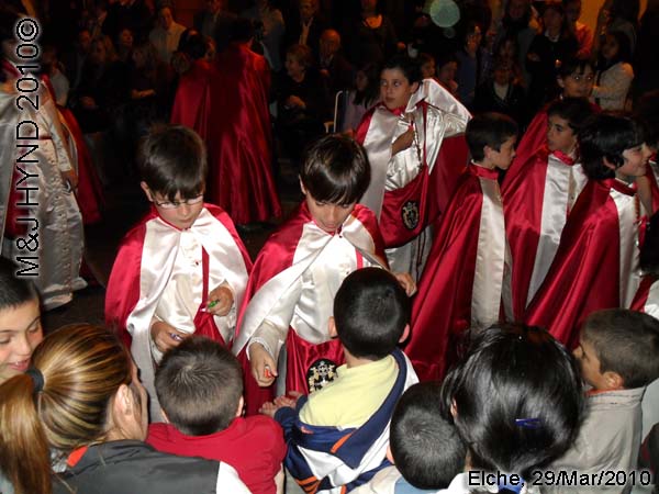  spain elche, Brotherhood long capes, procession giving sweets to spectators, near Townhall, crowded street parade 